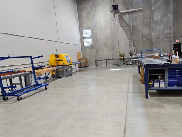 Industrial cutting station used to size aluminum flooring components at AMF Bruns facility