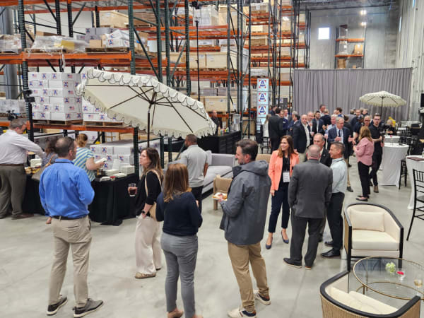Guests network and tour AMF Bruns warehouse during grand opening open house event