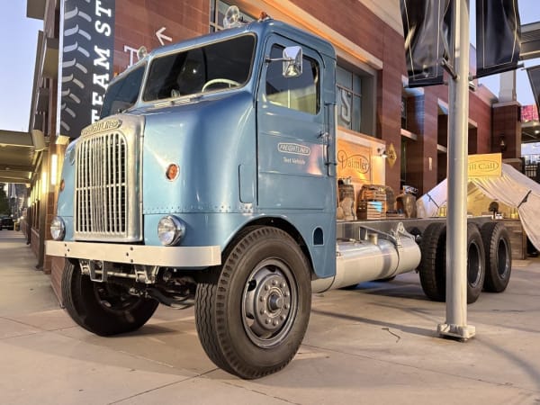 Antique blue shovelnose cabover Freightliner truck on display outside stadium