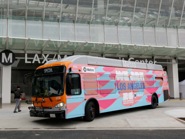 A Los Angeles Metro bus parking in front of a building.