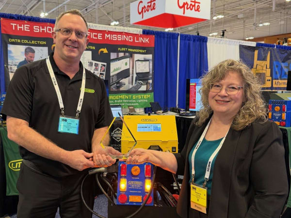Man and woman shaking hands with Top 20 trophy between them