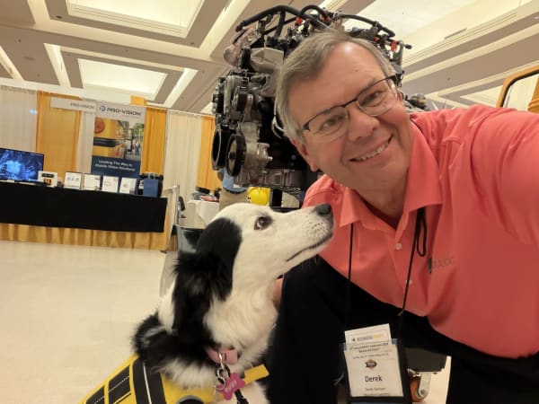 School Bus Fleet Editorial Advisory Board member Derek Graham poses with a school bus-themed therapy dog while visiting the Blue Bird exhibit during the NYAPT trade show.