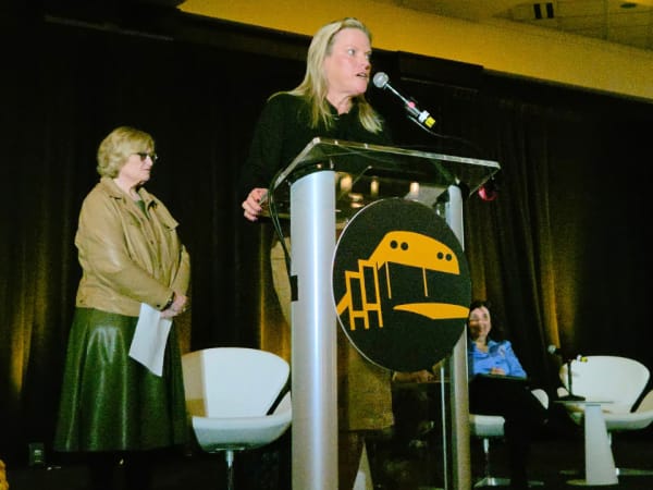Rebecca Pettit addresses attendees from the podium during a federal safety update session at NAPT ACTS 2026, with a panel of participants seated behind her.