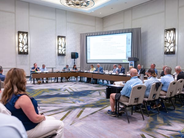 NSTA leadership conducts the association's business meeting, with board members seated at a long table discussing organizational updates during the 2026 annual conference.