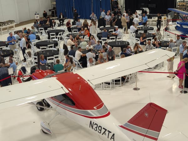 Conference attendees gather among historic aircraft exhibits during an evening networking event at the Wings Over the Rockies Air & Space Museum in Denver.
