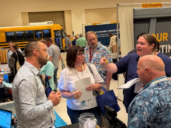 Attendees visit with exhibitors on the NYAPT trade show floor to learn about routing technology, safety products, and other transportation solutions.
