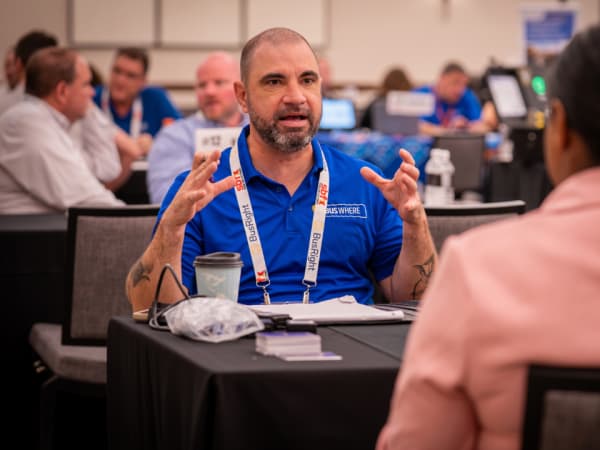 A BusWhere representative speaks with an attendee during a one-on-one meeting at School Bus Fleet Connex.