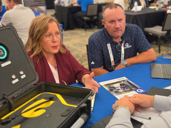 Q’Straint representatives discuss wheelchair securement solutions with a school transportation professional during a one-on-one meeting at School Bus Fleet ConneX.