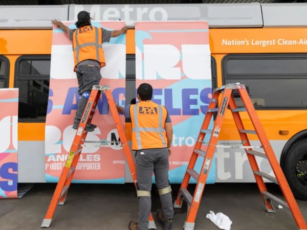 Crews apply World Cup branding to a Los Angeles Metro bus as the region welcomed tournament visitors.