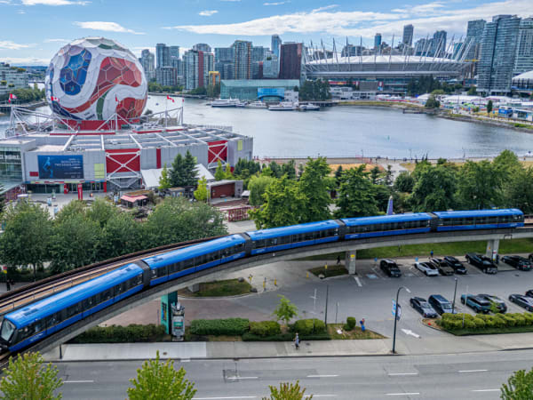 A TransLink train goes by a large FIFA World Cup soccer ball structure.