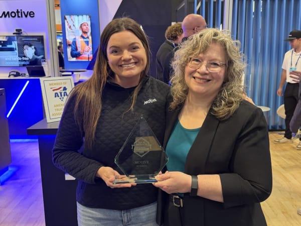 Two women posing with Top 20 trophy between them