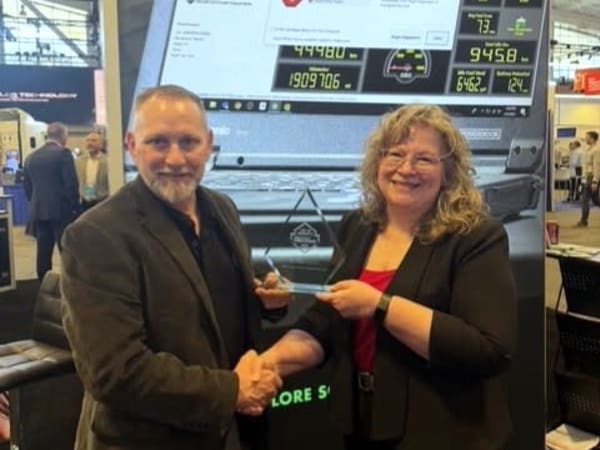 Man and woman shaking hands with Top 20 trophy between them