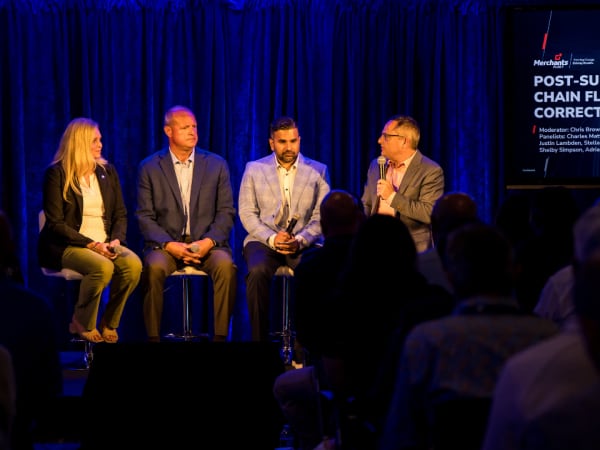 Four panelists on stage during seminar. 