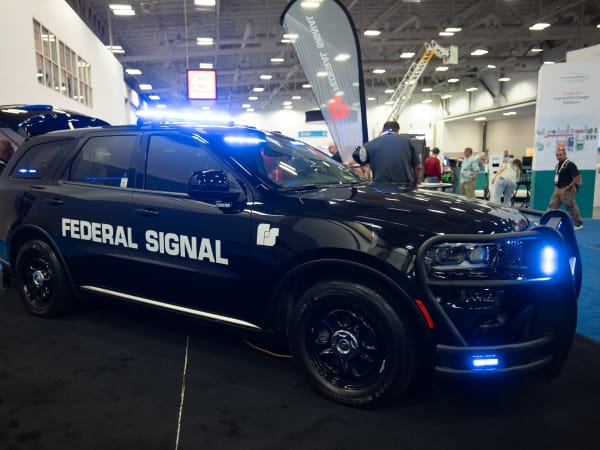 A black Dodge Durango Pursuit with a Federal Signal decal is shown with lights flashing.