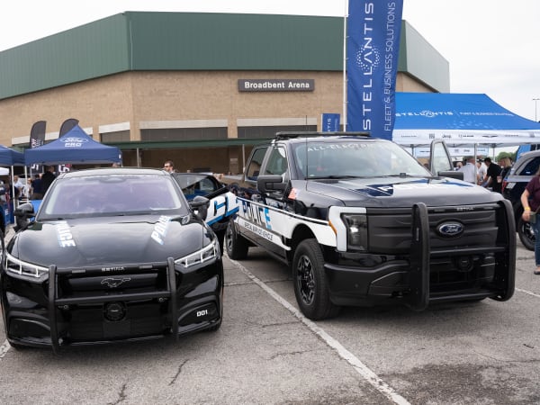 A black Ford Mustang Mach-E is shown next to a black Ford F-150 Lightning Pro SSV.