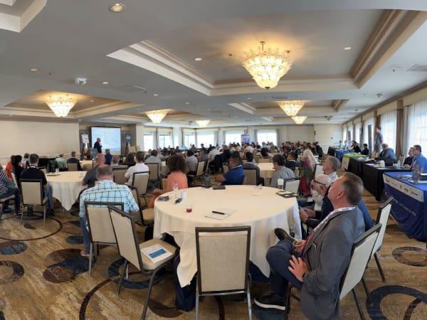 People in hotel conference room watching a speaker. 
