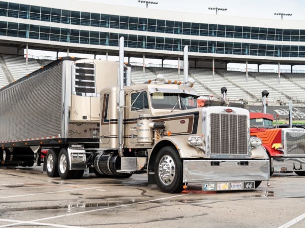 A beige Peterbilt Model 389 with trailer.