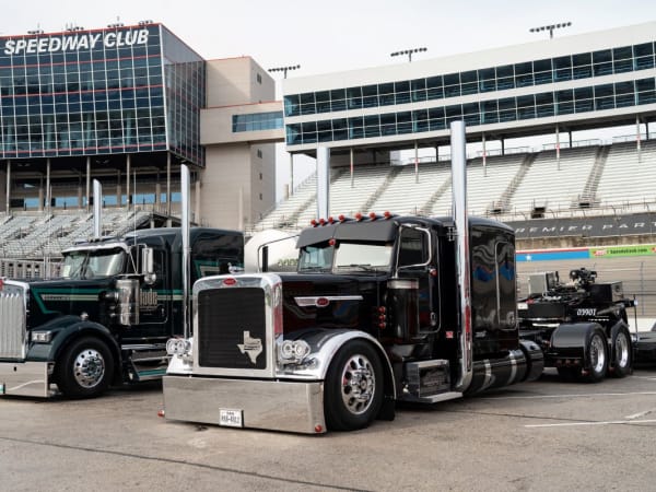 Kenworth and Peterbilt long-nose conventional trucks on display at the Texas Motor Speedway. 