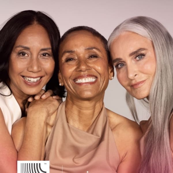 Three women over 50 exhibit beautiful skin and smile for the camera.