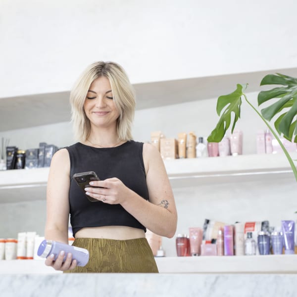 woman in salon scanning product with her phone