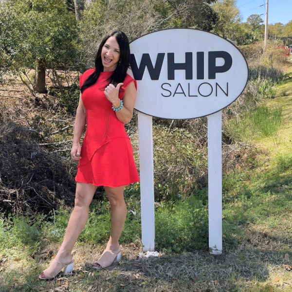 Owner Amy Pal in front of her Whip Salon sign