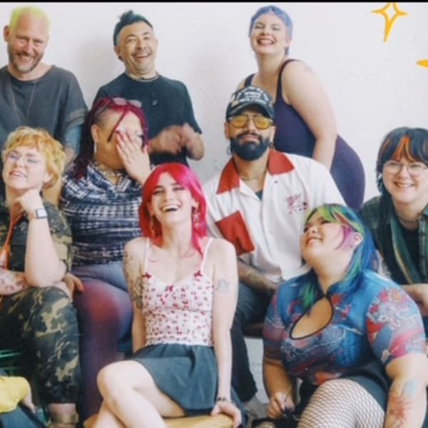 The colorful team from Chicago's Bang! Salon share a laugh while posing.