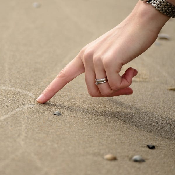 Drawing a heart in the sand.