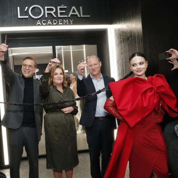 A ribbon cutting in front of the L'Oreal Academy.