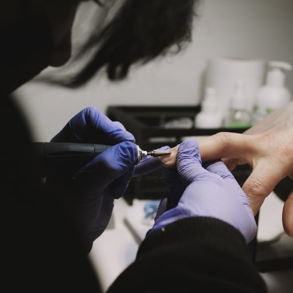 A nail technician performing a manicure.