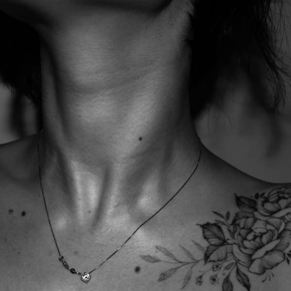 A photo of a flower tattoo on a shoulder of a woman.