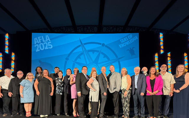 Honorees gather on stage for a photo. 