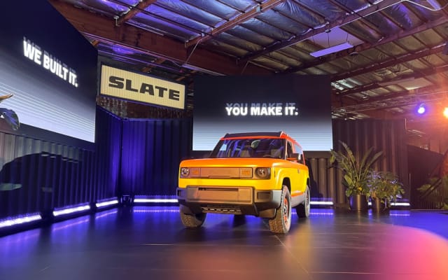 Yellow Slate pickup truck on a platform.