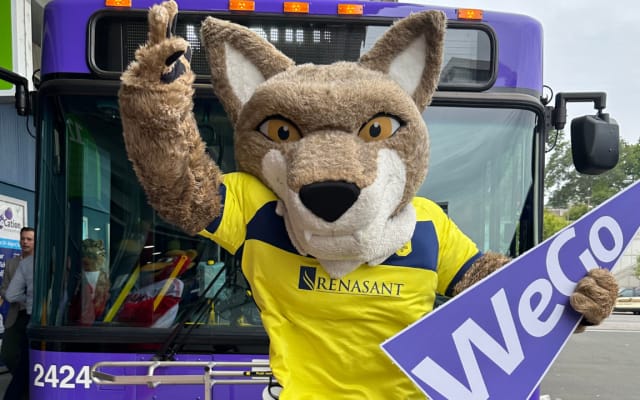 Nashville SC mascot poses in front of a purple WeGo Transit bus.