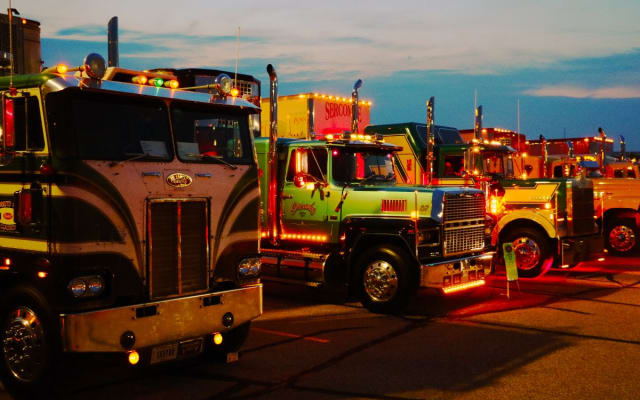 A line of antique trucks at sunset