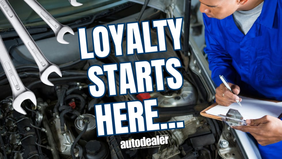 mechanic filling out clipboard while inspecting under hood of vehicle