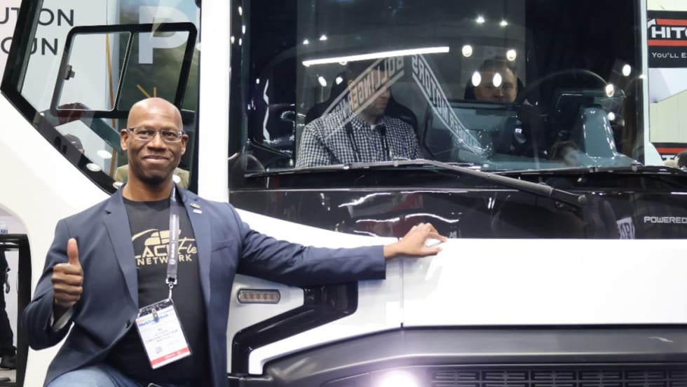 male fleet manager with thumbs up gesture while posing beside a REE P7-C electric truck during Work Truck Week 2024