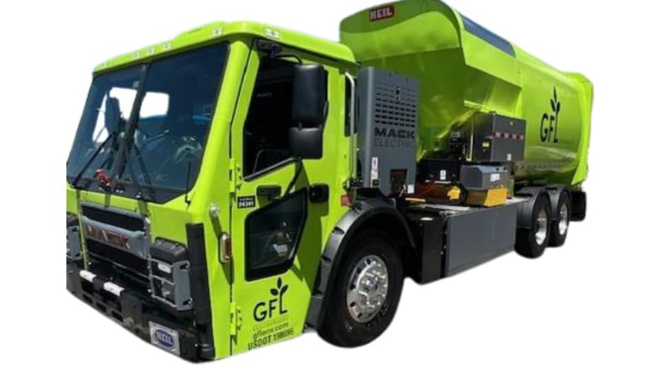 Green electric refuse truck with side loader.