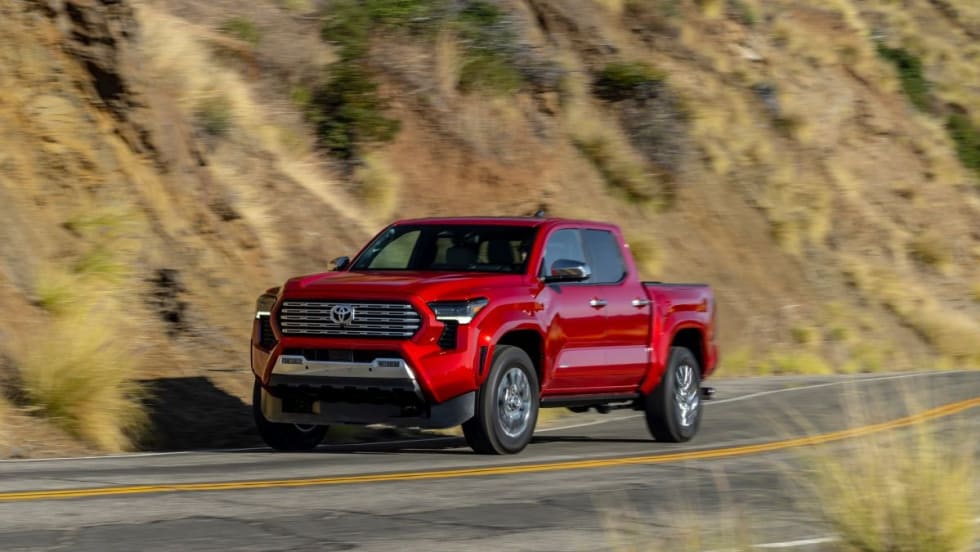 Red Toyota Tacoma driving down the street. 