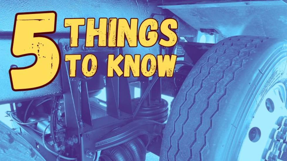 Blue-tinted image of a close-up photo of a truck tire and suspension for a lift axle. Top left has 5 Things to Know in large yellow type.