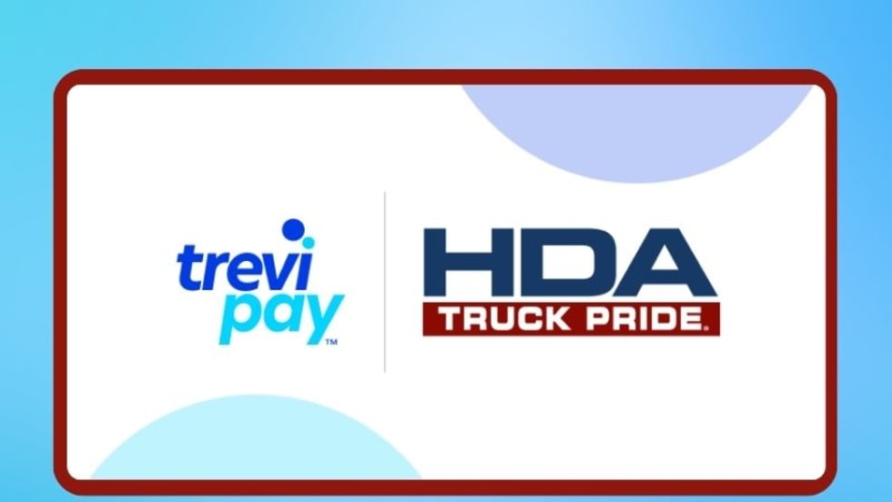 White sign shows logos for two companies, TreviPay and HDA Truck Pride, against a blue background.