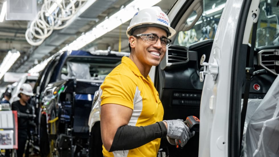 Smiling auto assembly worker on the assembly line.