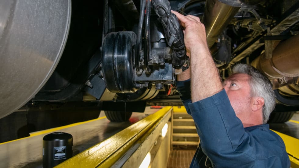 Mechanic working on a vehicle on a lift.
