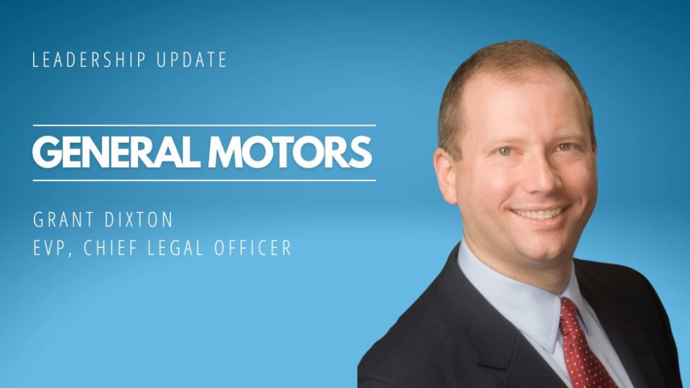 A man in a suit and tie smiling, with the words "General Motors" in the background.