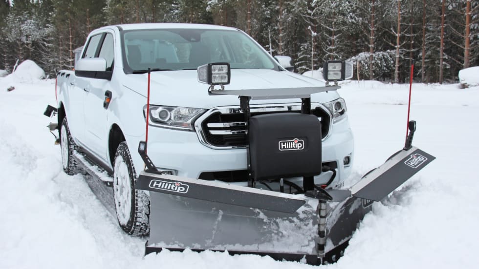White truck with attached snow plow, ideal for winter maintenance.