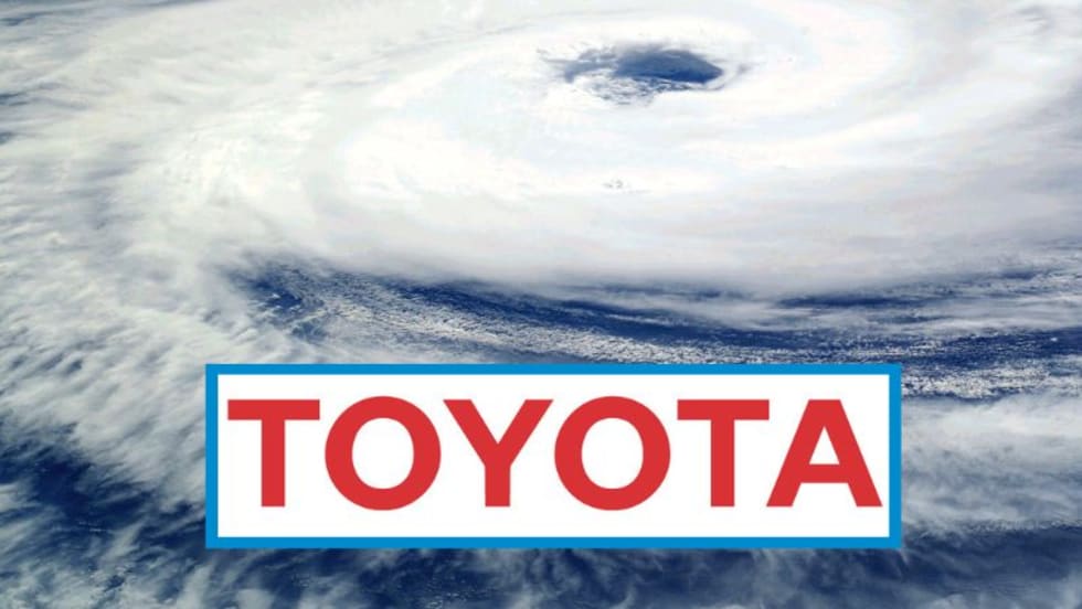 Toyota corporate logo in front of an image of a hurricane.