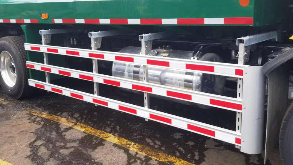 A green truck with a red and white stripe on the side.