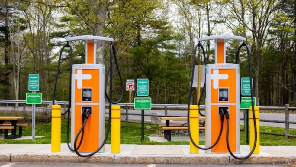 Two electric charging stations with orange and white signs.