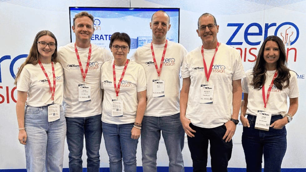 Group of six people standing in front of a ZeroMission background.