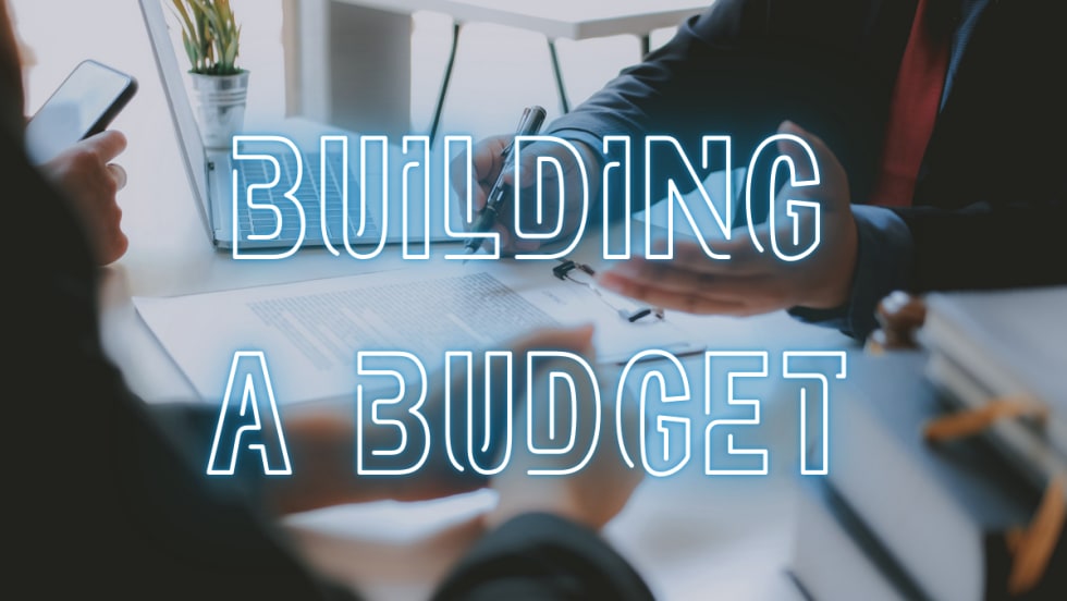 Building a Budget over image of working people at a desk budgeting