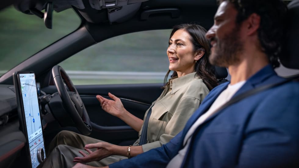Two people talking in a car, while one drives hands-free.